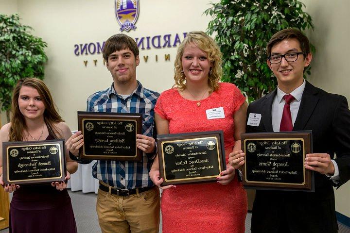 Students display their honors program plaques.
